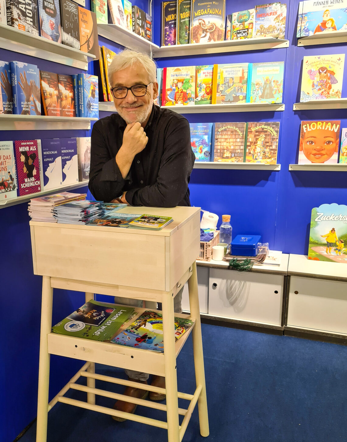 Michael Böhme steht an einem Hochtisch in einer Buchhandlung
