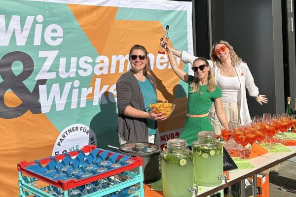 Drei Frauen bereiten gemeinsam Aperol Spritz für das Hoffest zu.