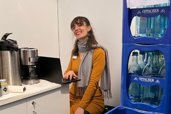 Rahel Trotta im Backstage-Büro inmitten von Wasserkästen auf der Leipziger Buchmesse 2024.