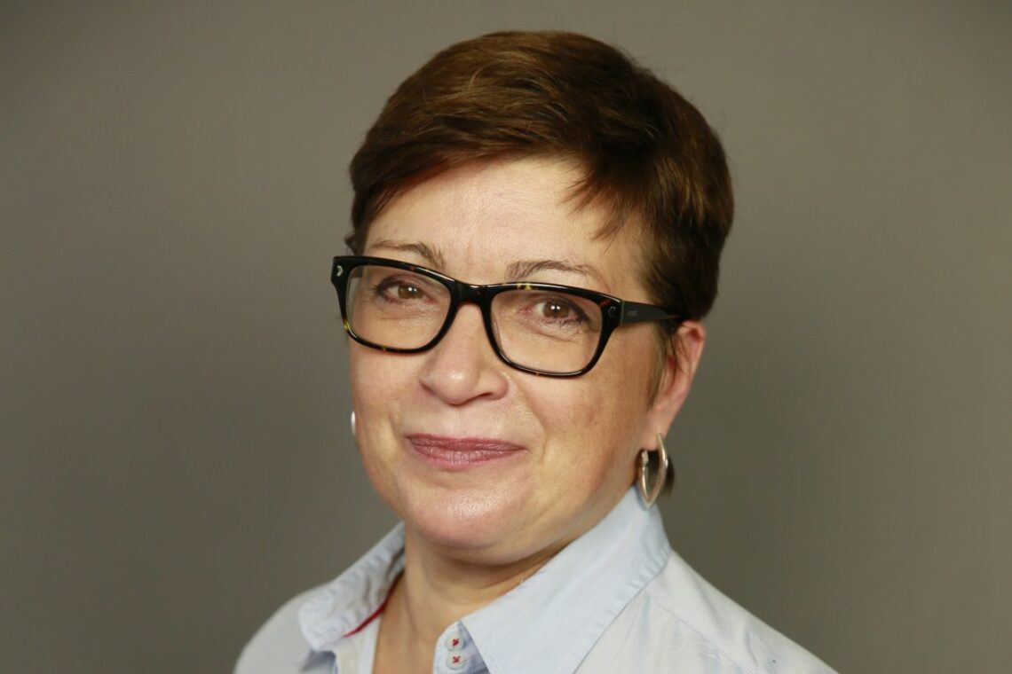 Porträt von Eva Singer von Harper Collins Germany vor einer Wand.