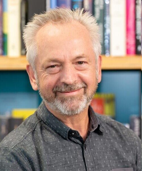 Porträt von Dieter Dausien vor einem Bücherregal.