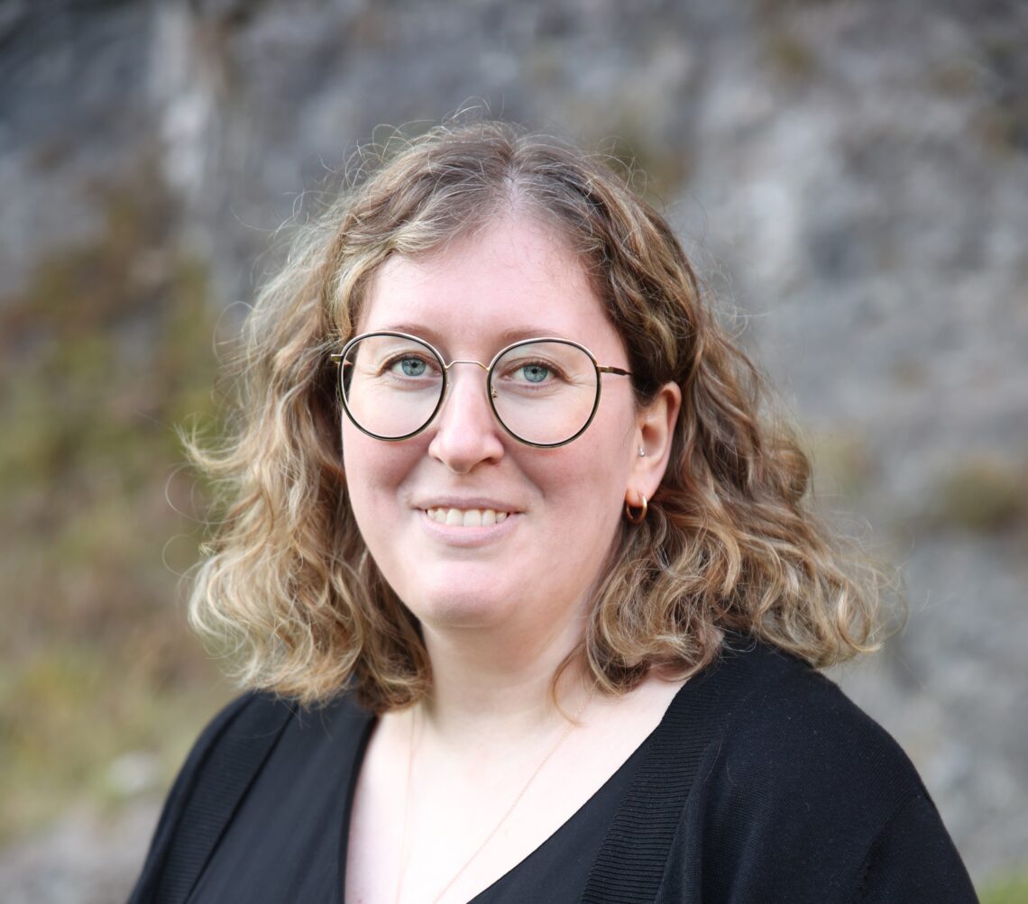 Porträt von Verena Gruber vor einer Steinfassade.