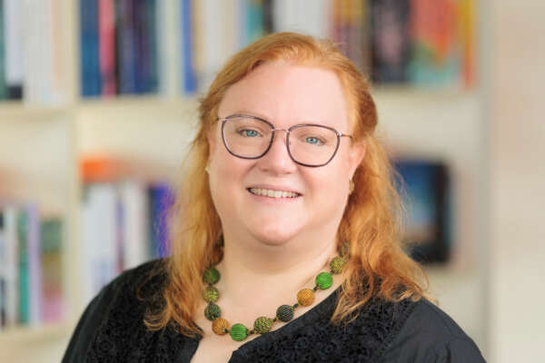 Porträt von Barbara Huechting vor einem Bücherregal in der Buchhandlung Findorffer Bücherfenster.