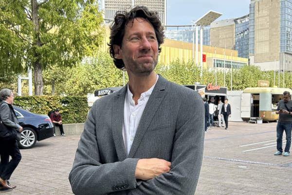 David Mesche mit einem schmunzeln und verschränkten Armen auf dem Gelände der Frankfurter Buchmesse.
