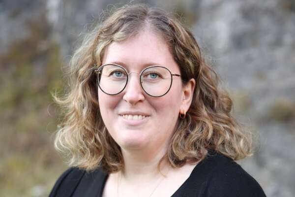 Porträt von Verena Gruber vor einer Steinfassade.