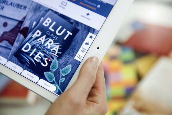 Ausschnitt eines Tablets was einen Buchtitel auf VLB-TIX zeigt gehalten von einer Hand.