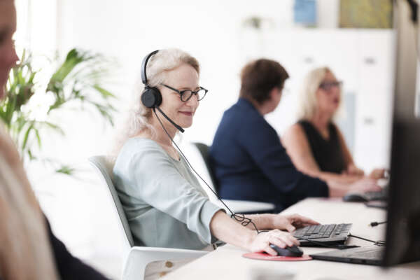 Mehrere Frauen sitzen in einer Reihe im Coworking Space am Computer.