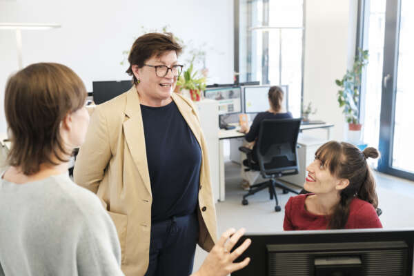 Frauen unterhalten sich am Arbeitsplatz.