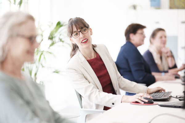 Frauen sitzen Coworking Space am Computer.